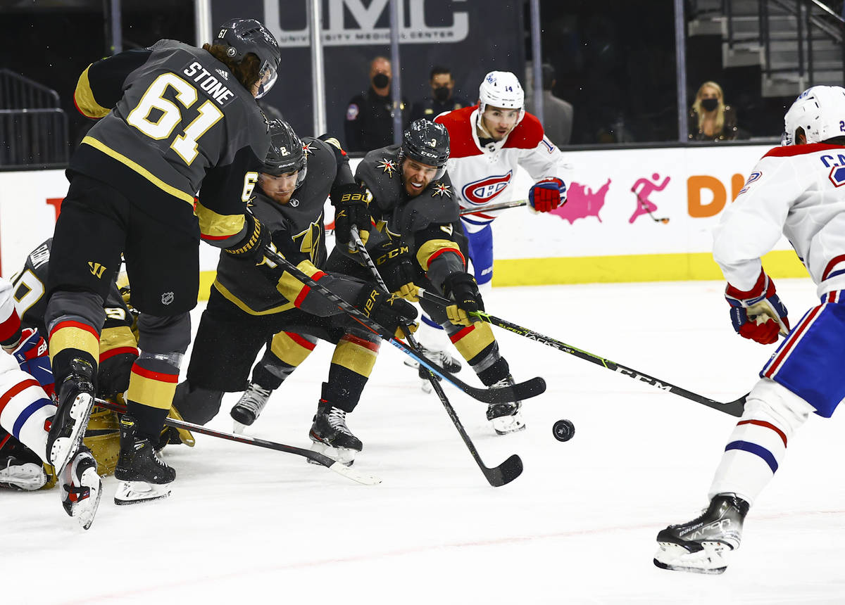 Golden Knights defensemn Zach Whitecloud (2) and Brayden McNabb (3) clear the puck against the ...