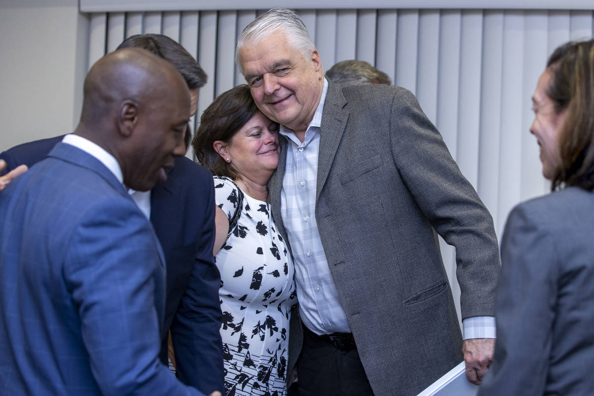 Gov. Steve Sisolak hugs Betsy Fretwell about others during the Nevada COVID-19 Response, Relief ...