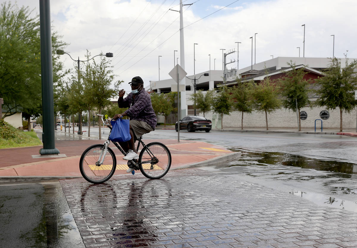 A cyclist who gave his name as Prophet rides after a light rain on 7th Street at Gass Avenue in ...