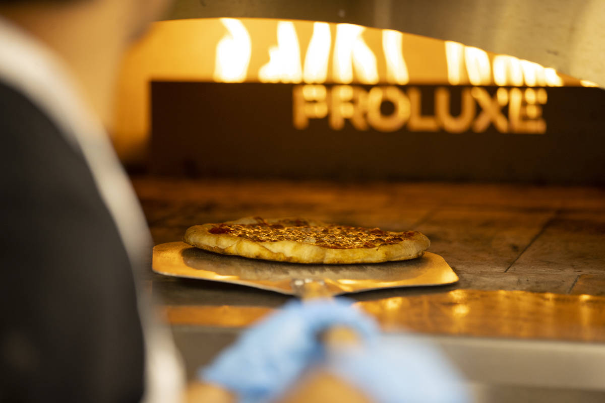 A pizza is taken out of the oven at the Fly Pie pizza drive-thru at the intersection of St. Ros ...
