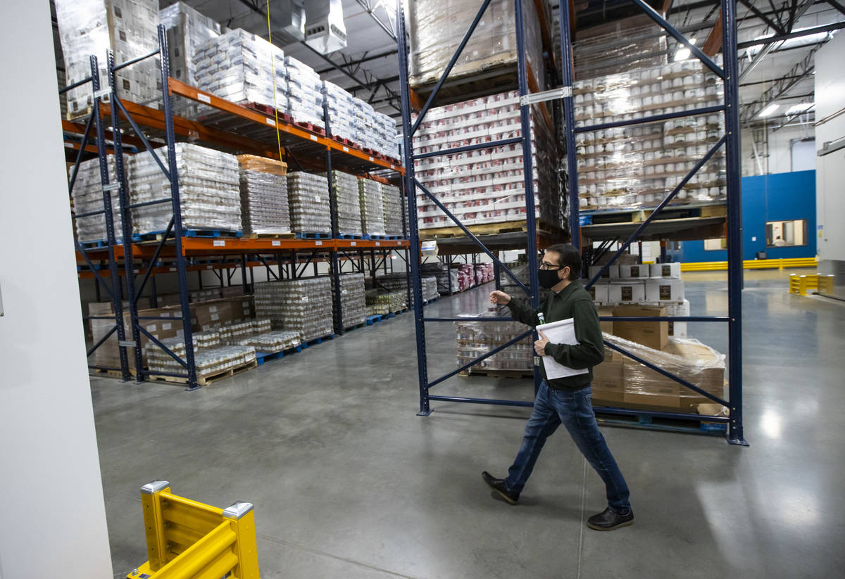 Joe Ham, director of marketing and communications at Three Square, walks through the warehouse ...