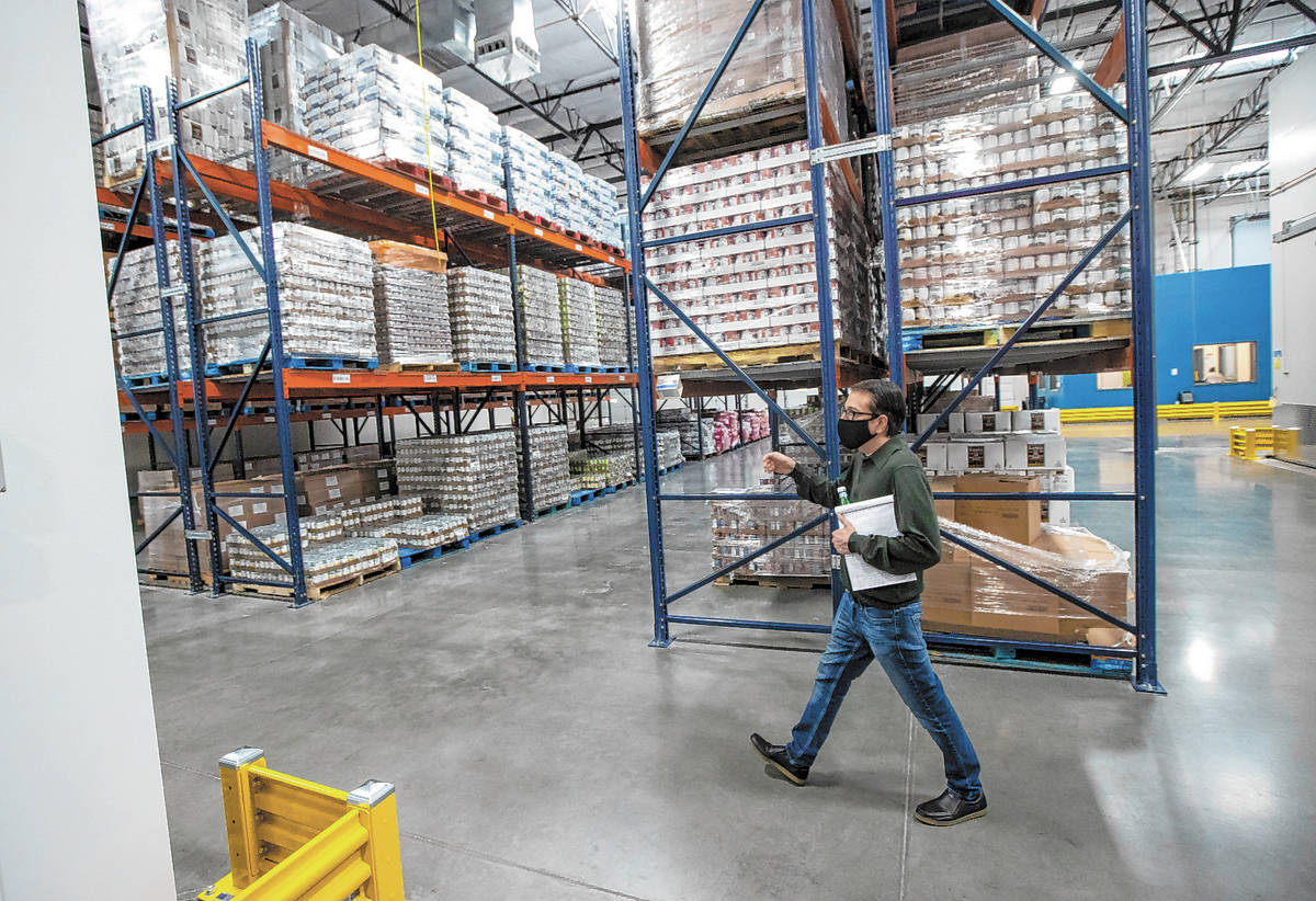 Joe Ham, director of marketing and communications at Three Square, walks through the warehouse ...
