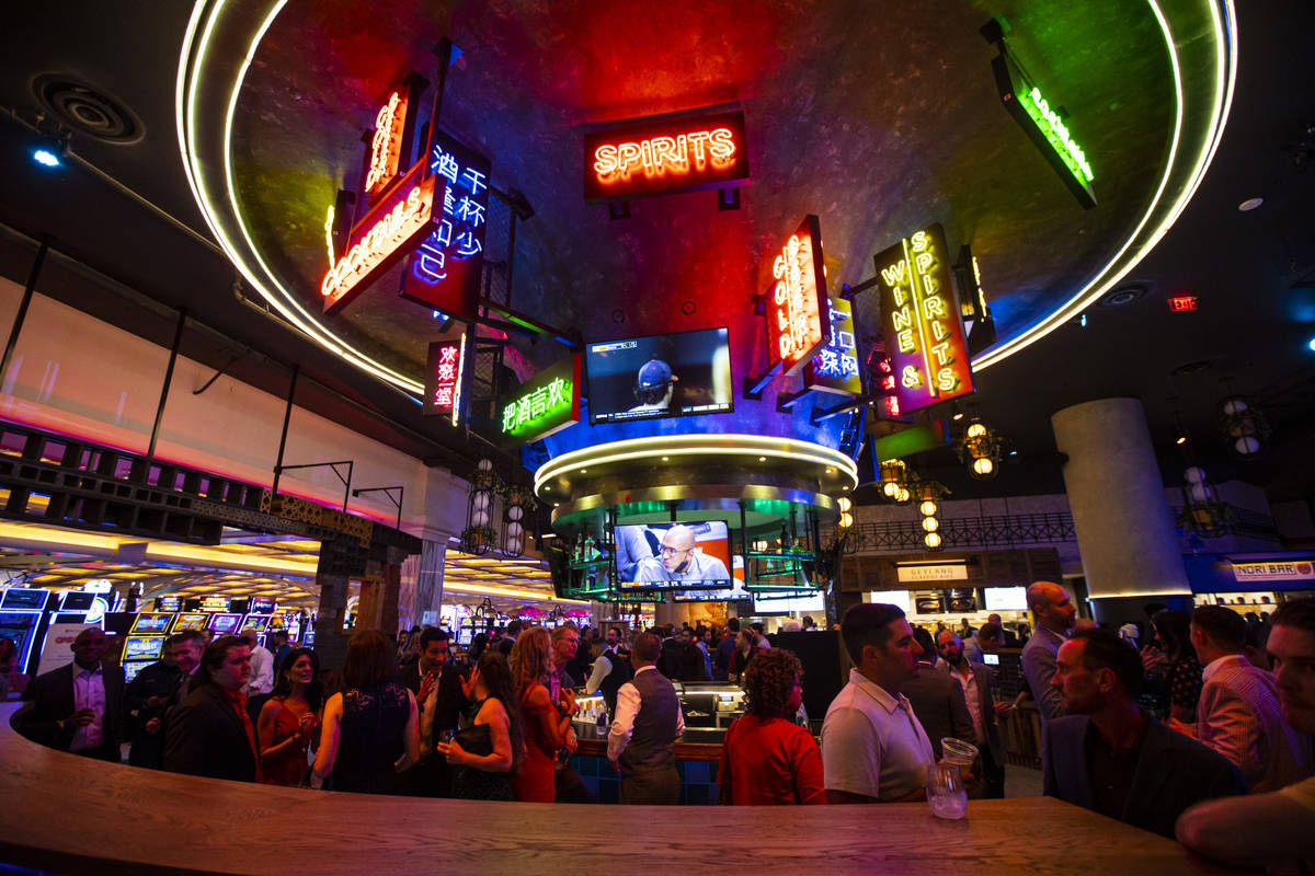 People mingle and drink cocktails by a bar at the Famous Foods Street Eats area during the open ...