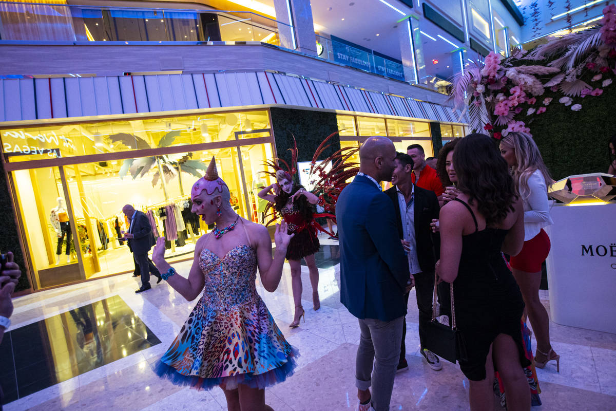 Costumed performers entertain the crowd in The District during the opening night of Resorts Wor ...