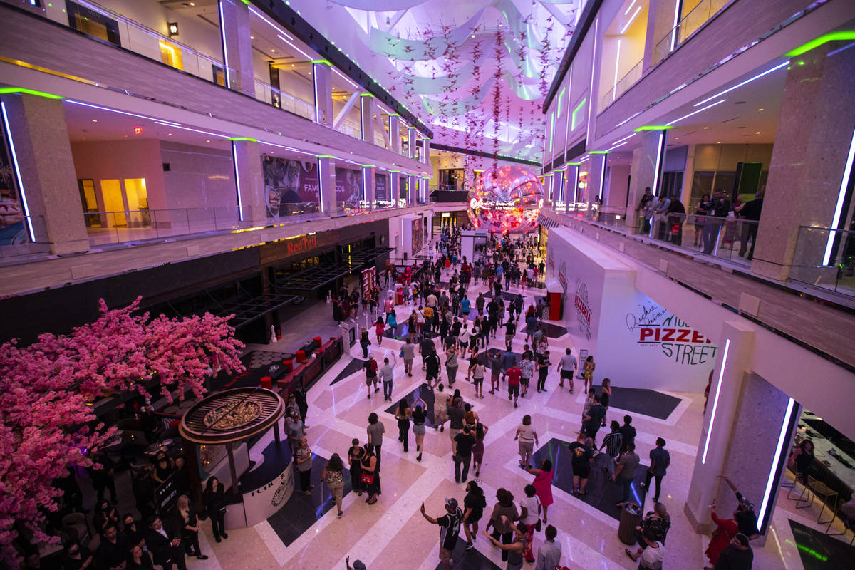 People walk into The District as the doors open to the public at Resorts World Las Vegas on Thu ...