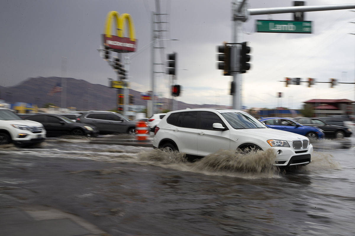 Motorists drive through flooding at the intersection of South Lamb Boulevard and East Charlesto ...
