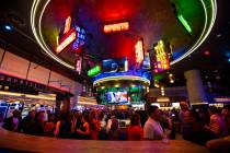 People mingle and drink cocktails by a bar at the Famous Foods Street Eats area during the open ...