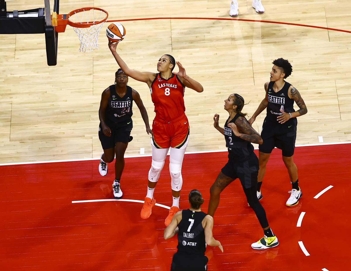 Las Vegas Aces' Liz Cambage (8) goes to the basket between Seattle Storm's Jewell Loyd (24) and ...
