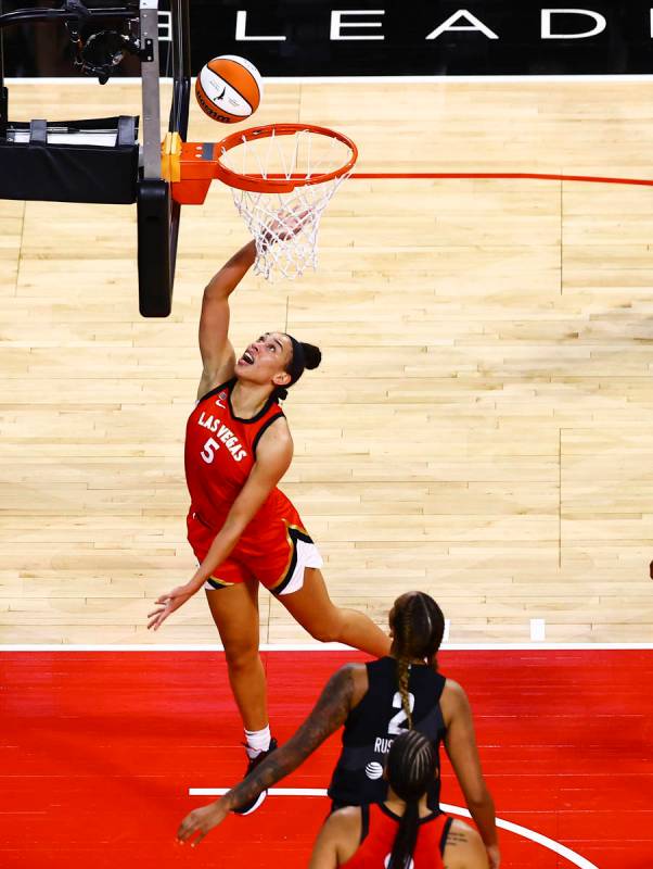 Las Vegas Aces' Dearica Hamby (5) goes to the basket in front of Seattle Storm's Mercedes Russe ...