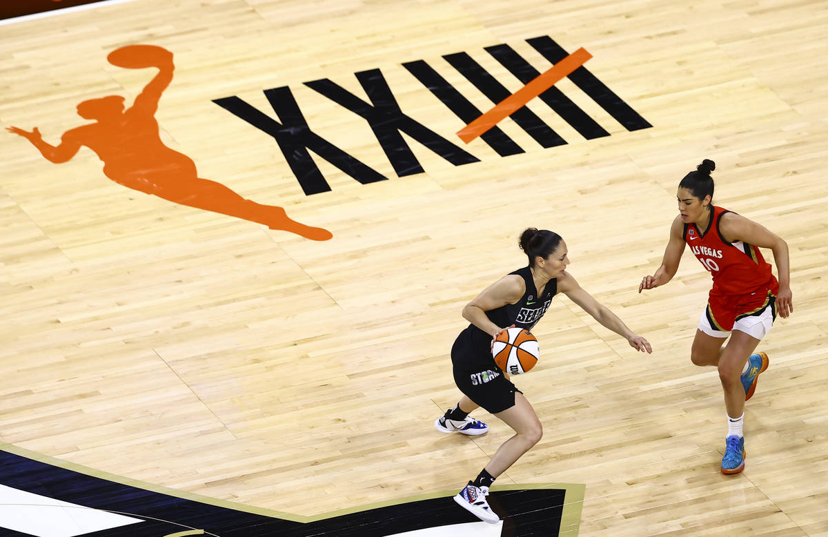 Seattle Storm's Sue Bird, left, drives the ball under pressure from Las Vegas Aces' Kelsey Plum ...