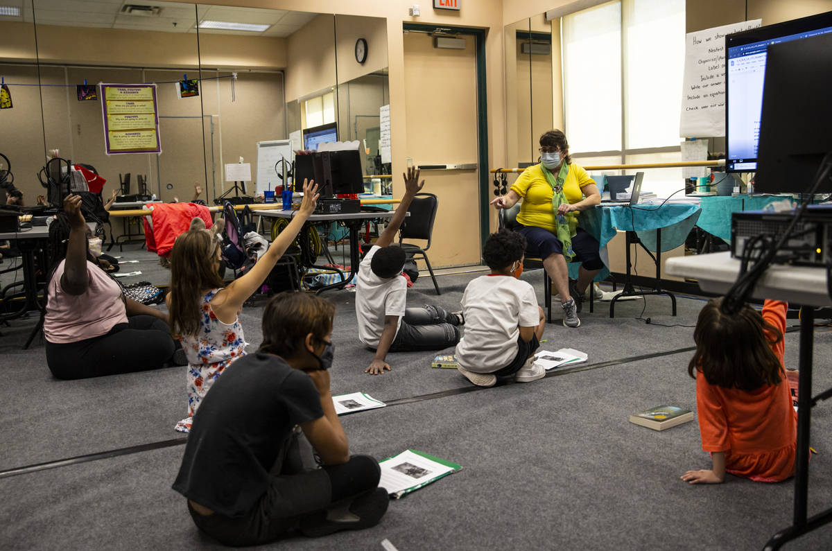 Students raise their hands as learning guide Tammy Slank, right, leads a discussion during a th ...