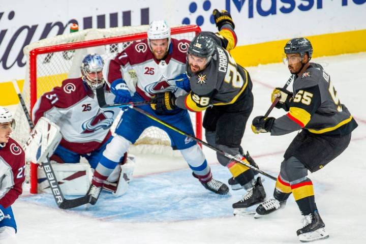 Golden Knights left wing William Carrier (28) and Colorado Avalanche defenseman Devon Toews (7) ...