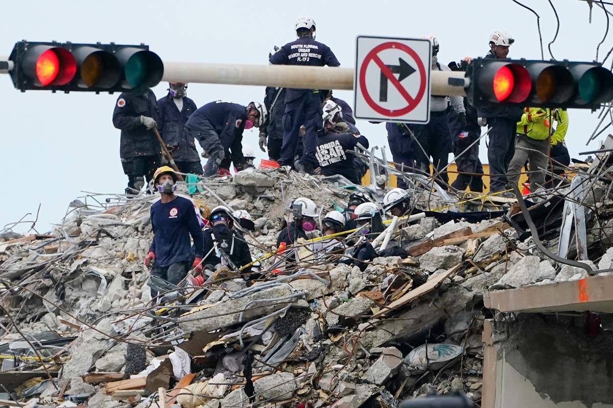 A rescue worker pauses to look up at what remains of the Champlain Towers South residential bui ...