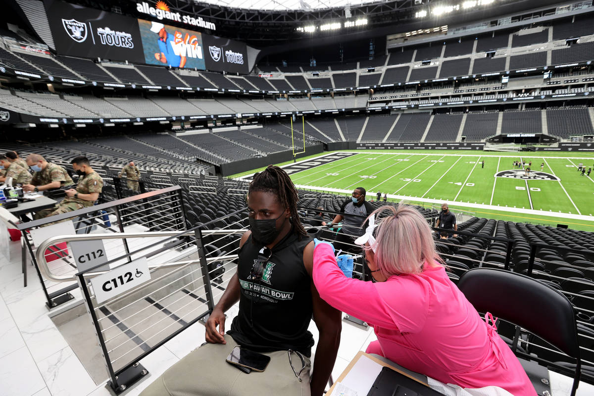 Desiree Crunk gives a shot to Ikem Okeke, 22, of Las Vegas during a COVID-19 vaccination clinic ...