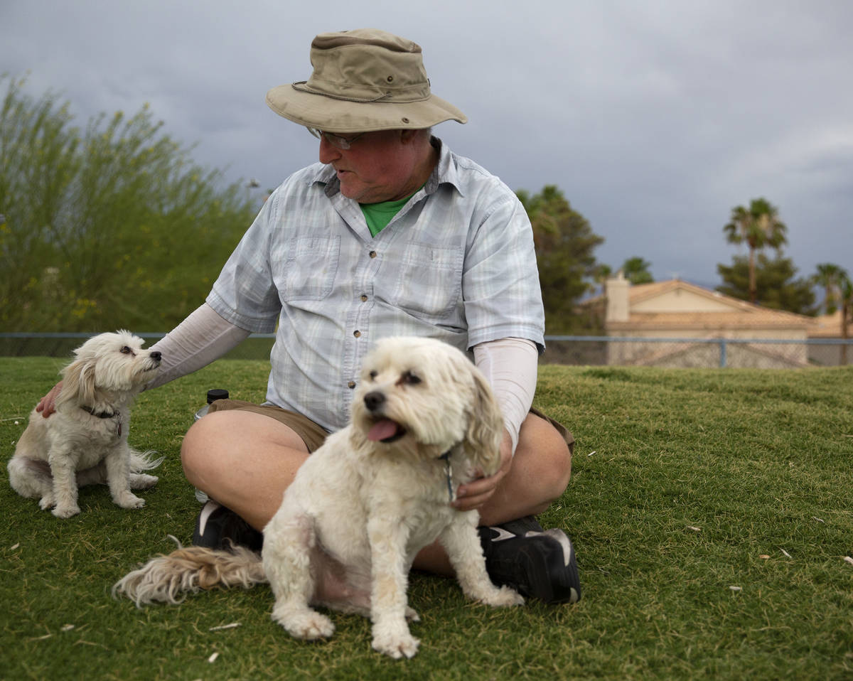 Jim Gunther, of Las Vegas, pets his two dogs Nee Nee, left, and George, right, at Kellogg Zaher ...