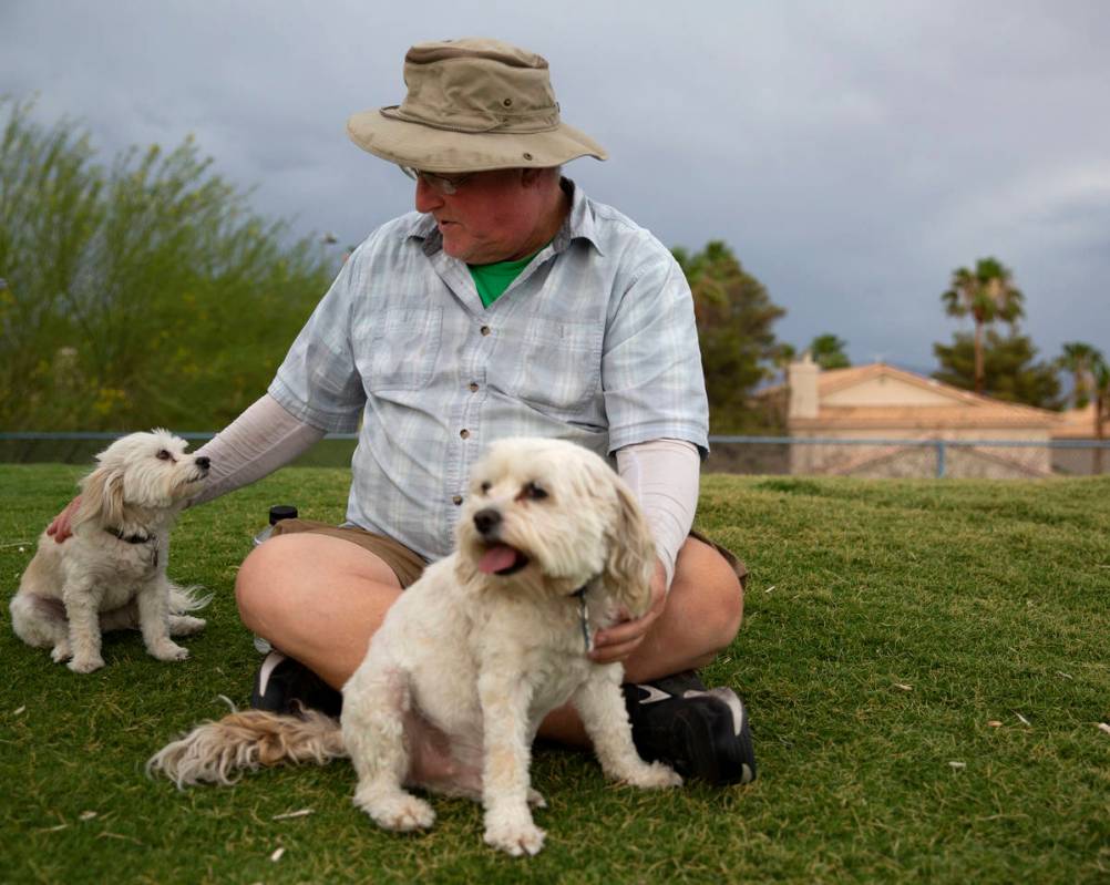 Jim Gunther, of Las Vegas, pets his two dogs Nee Nee, left, and George, right, at Kellogg Zaher ...