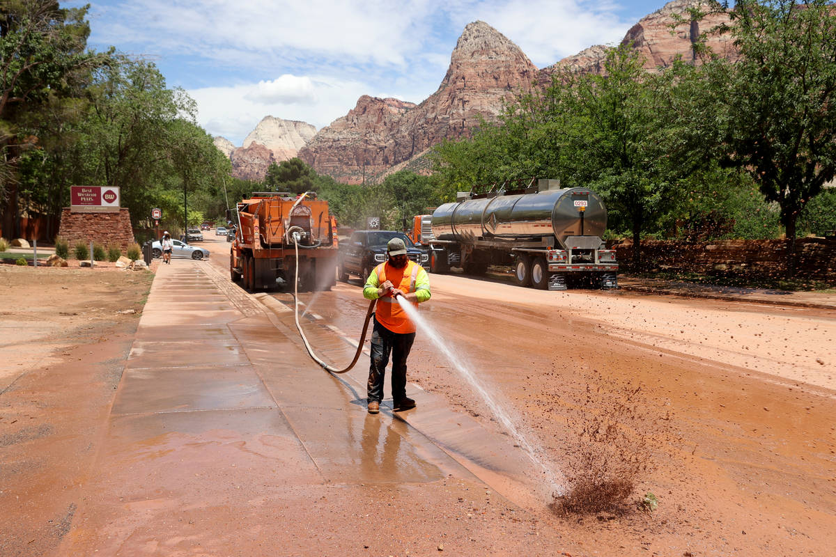 Workers clean Zion Park Boulevard and State Route 9 in Springdale, Utah Wednesday, June 30, 202 ...