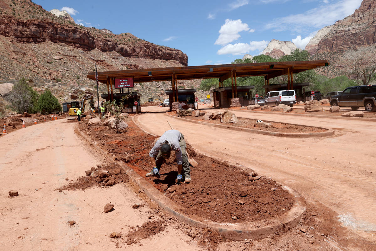 Workers clean clean the main entrance to Zion National Park near Springdale, Utah Wednesday, Ju ...