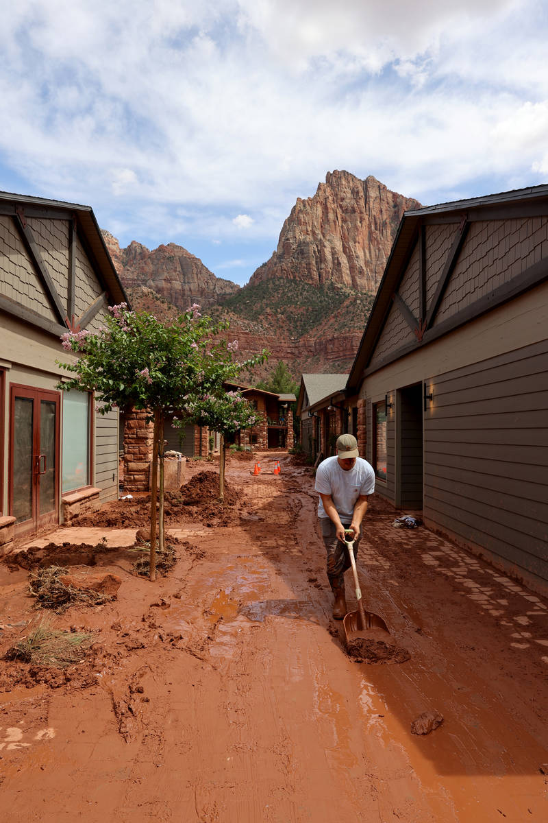 Workers clear mud and debris in Zion Canyon Village in Zion National Park near Springdale, Utah ...