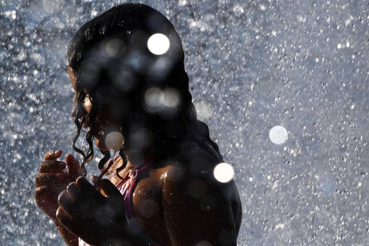 Cora Richardson, 7, cools off in the Rotary Fountain at Riverfront Park on Tuesday, June 29, 20 ...