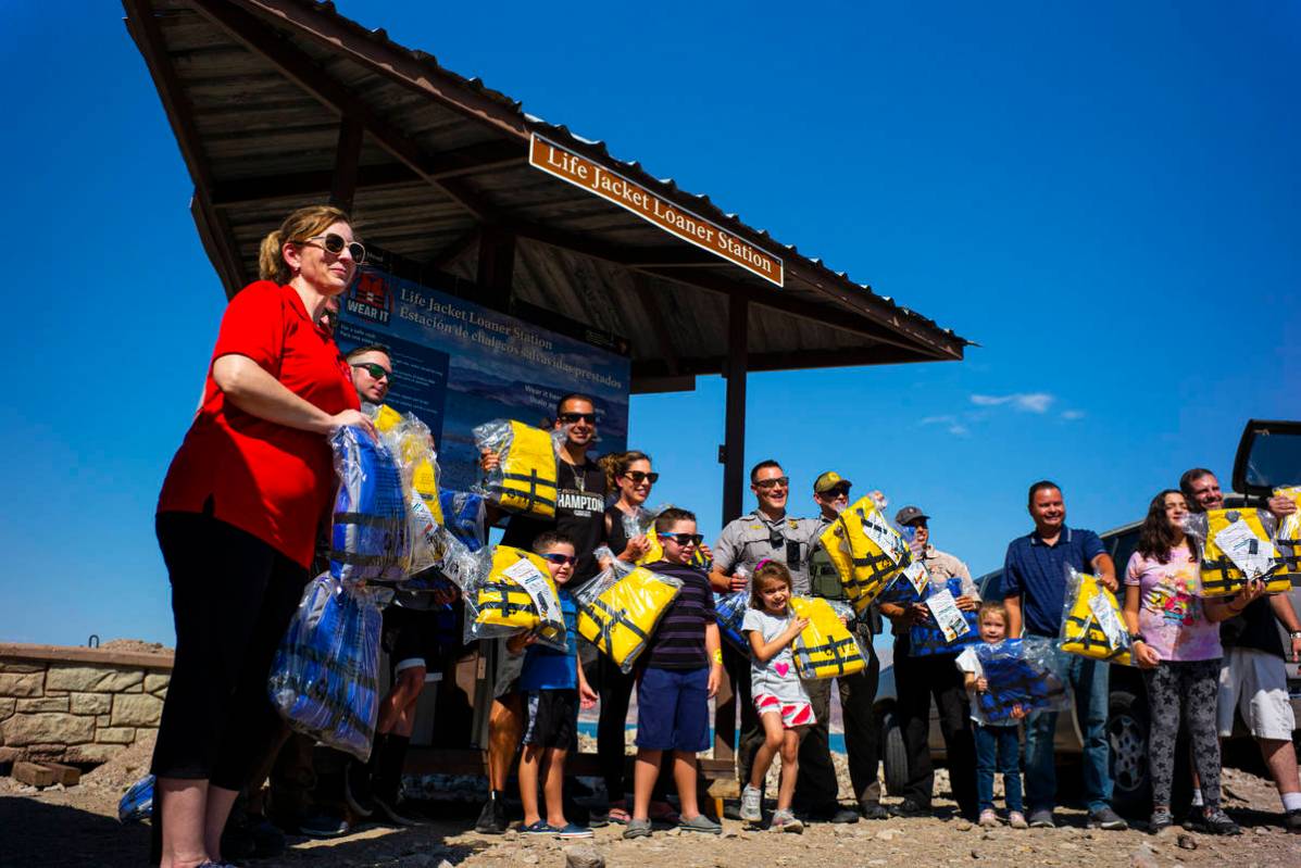 Lifejackets are delivered to park rangers as they pose for a picture at Boulder Beach at Lake M ...