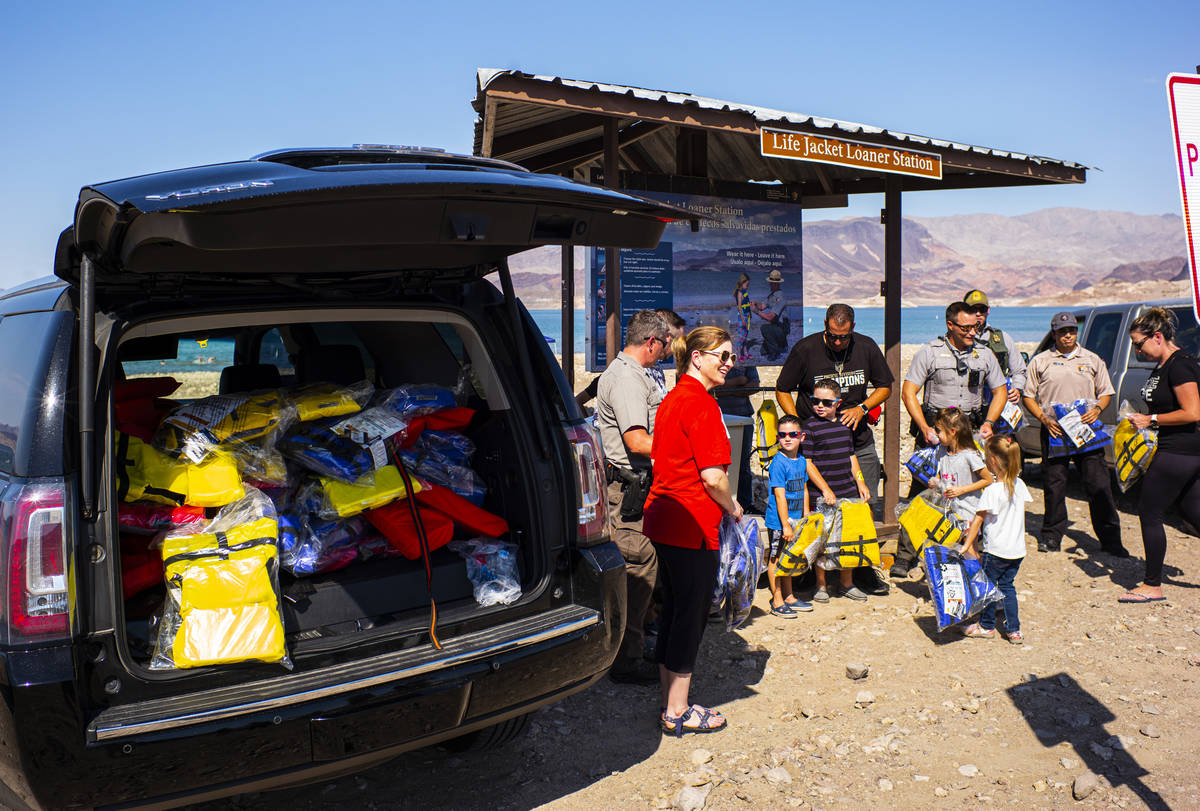 Lifejackets are delivered to park rangers as they pose for a picture at Boulder Beach at Lake M ...