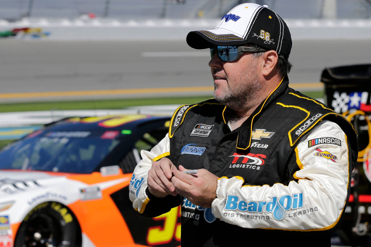 Brendan Gaughan walks along pit road during NASCAR auto race qualifying at Daytona Internationa ...