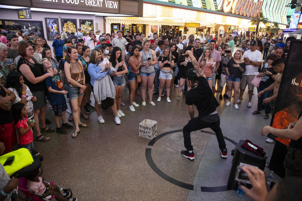 People watch a performer at the Fremont Street Experience in Las Vegas, Friday, July 2, 2021. ( ...