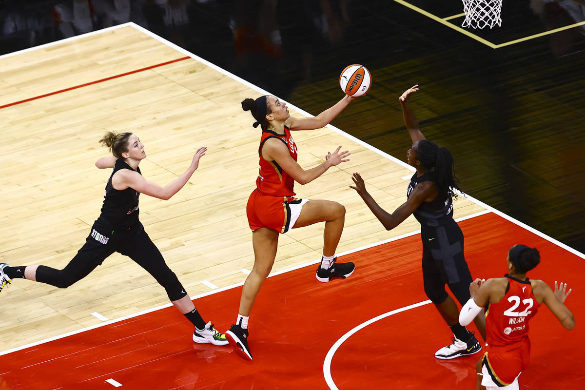 Las Vegas AcesÕ Dearica Hamby, center, drives to the basket between Seattle StormÕs K ...