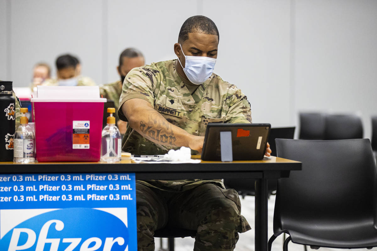 Nevada National Guard Spc. Demetrie Barnett works at his station at the vaccination clinic at t ...