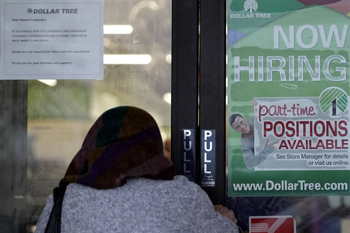 A shopper enters a retail store as a hiring sign shows in Buffalo Grove, Ill., Thursday, June 2 ...