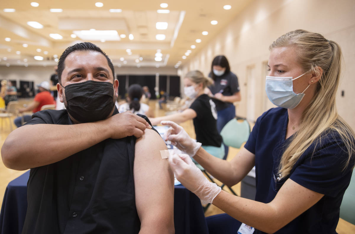 Jose Padilla, left, gets his COVID-19 vaccination from Touro University Nevada physician assist ...