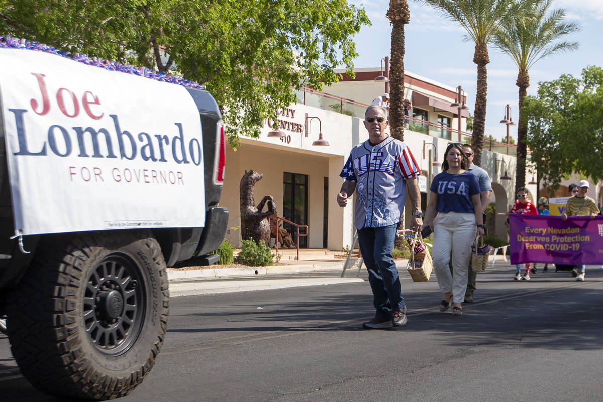 Clark County Sheriff Joe Lombardo, right, marches through the Damboree parade to promote his ru ...