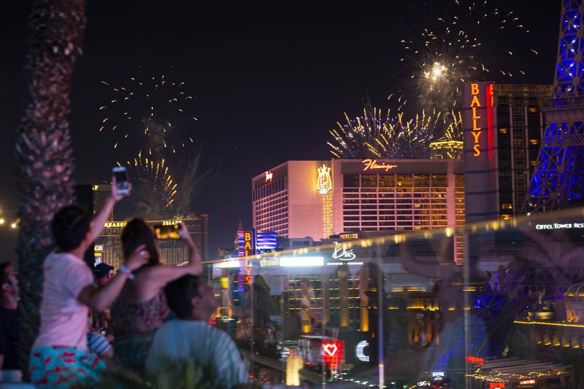 Fireworks go off along the Las Vegas Strip as people watch from the Boulevard Pool at The Cosmo ...