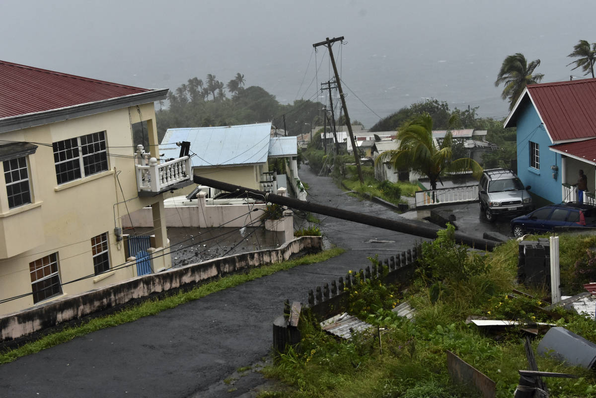 An electrical pole felled by Hurricane Elsa leans on the edge of a residential balcony, in Ceda ...