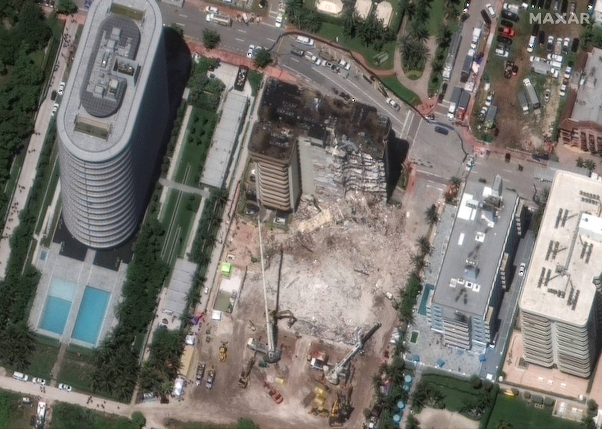 In this satellite image provided by Maxar Technologies heavy-lift cranes are used to aid in the ...