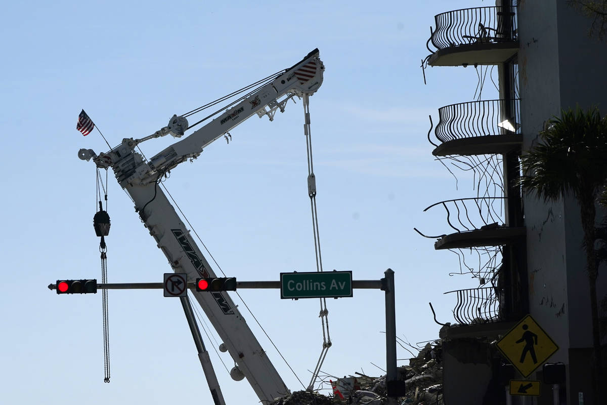 An American flag flies from a crane next to the Champlain Towers South condo building, where sc ...