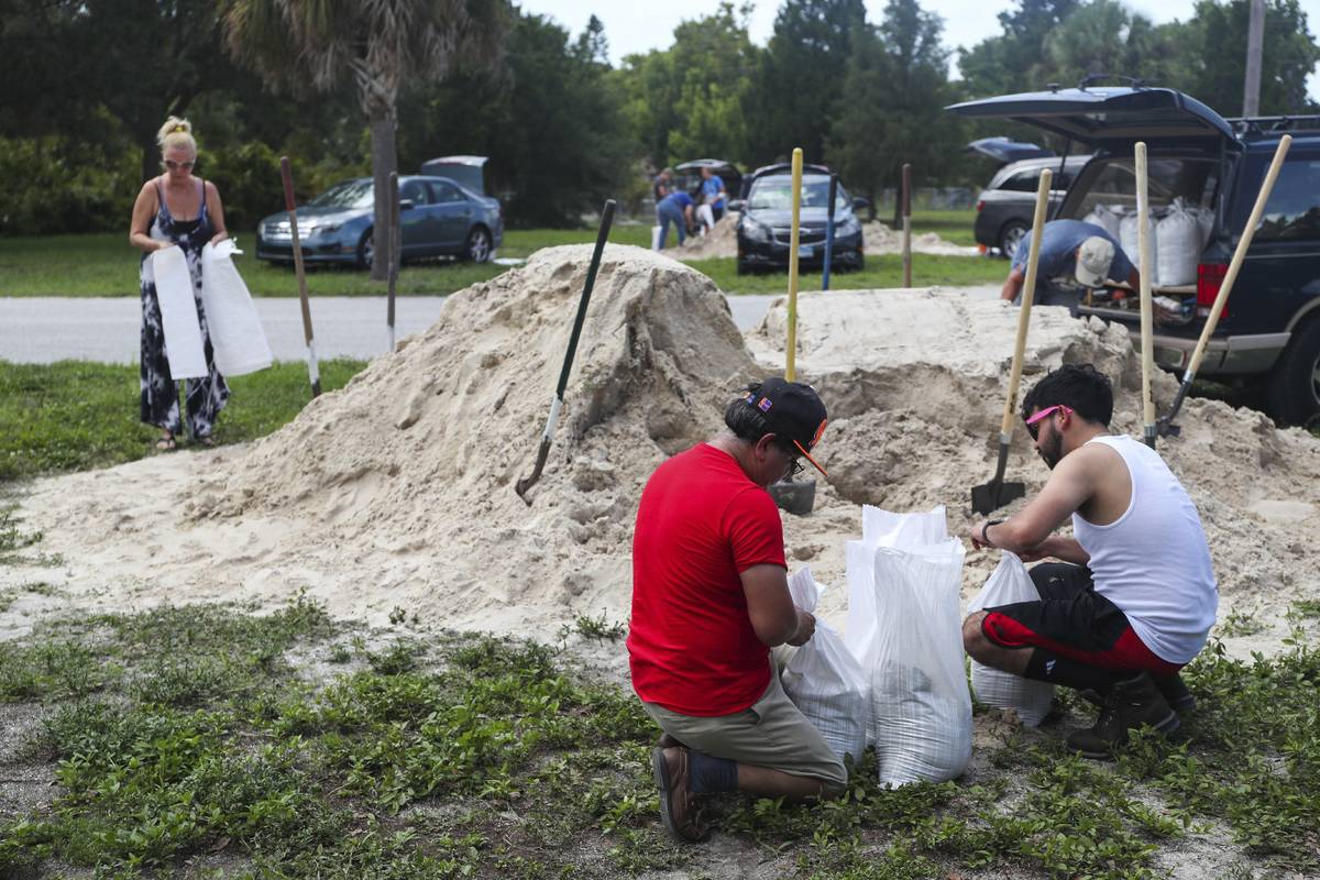 People fill sandbags to prep for storm Elsa at Walsingham Park, Monday, July 5, 2021 in Seminol ...
