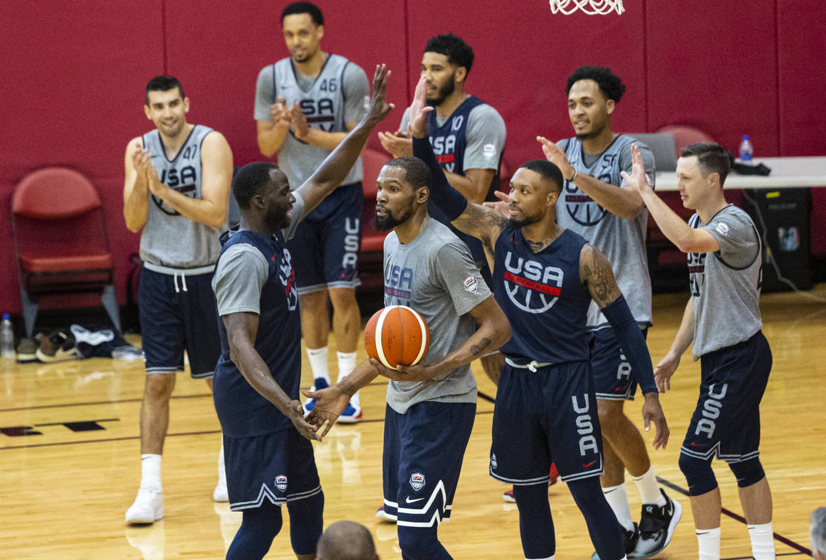 Draymond Green, lower left, high-fives Kevin Durant, center, and Damian Lillard, right, during ...