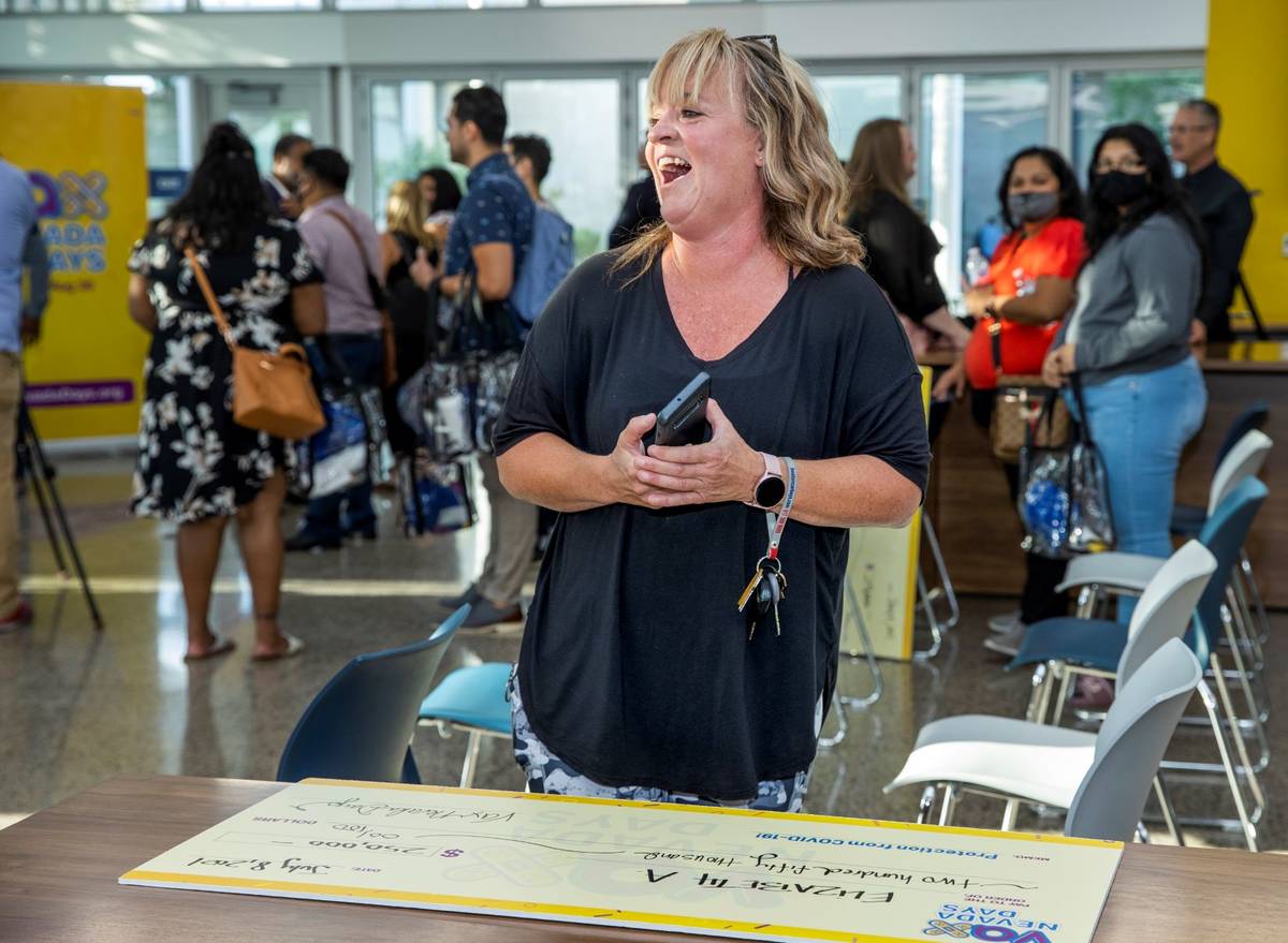 Teacher Elizabeth Allder laughs after calling her husband winning $250,000 as Governor Steve Si ...