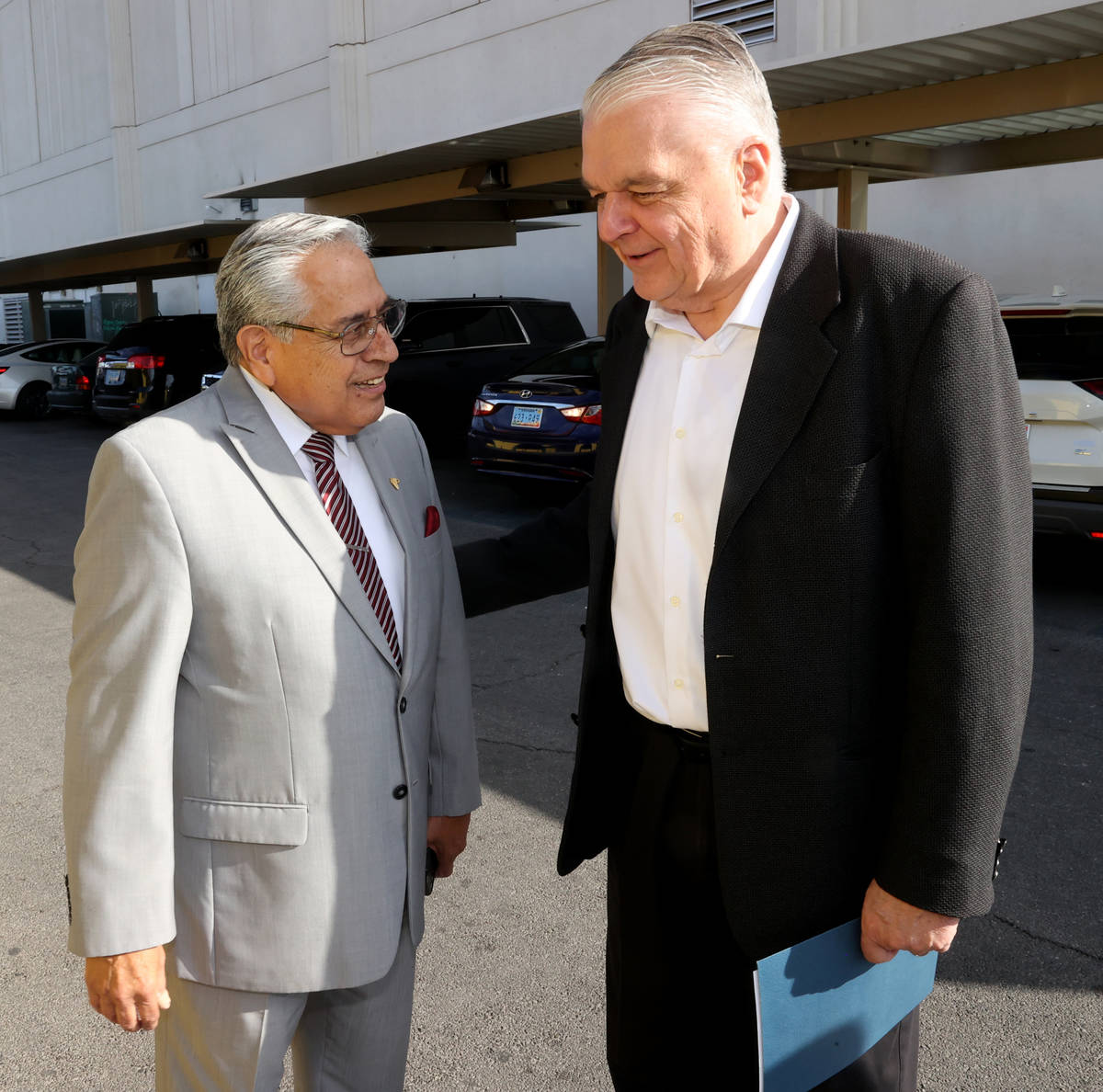 Gov. Steve Sisolak, right, greets Fernando Romero, president of Hispanics in Politics at the gr ...