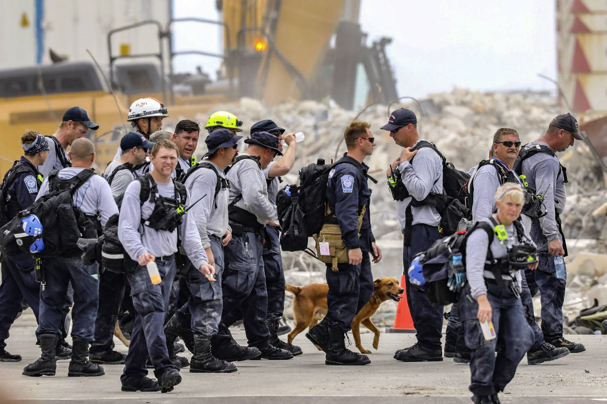 Search and rescue team members depart after working the debris field of the Champlain Towers So ...