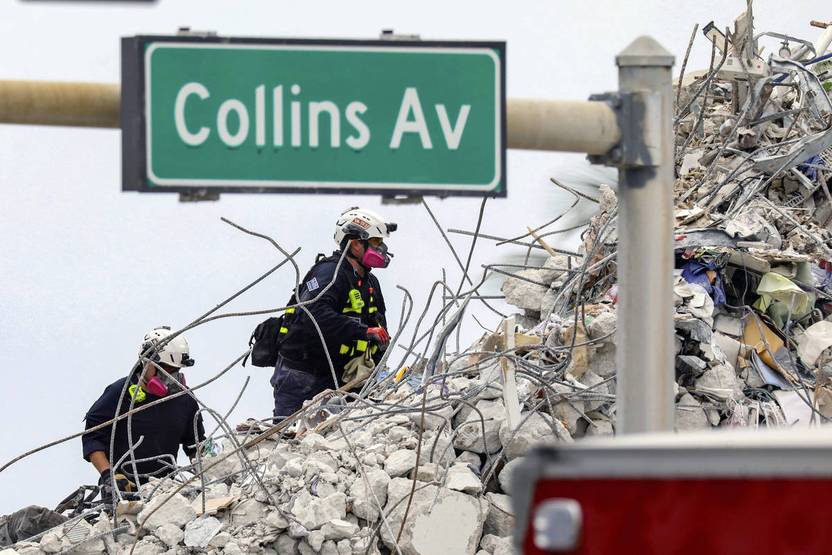 A search and rescue team members climb the rubble of the Champlain Towers South condo, Wednesda ...