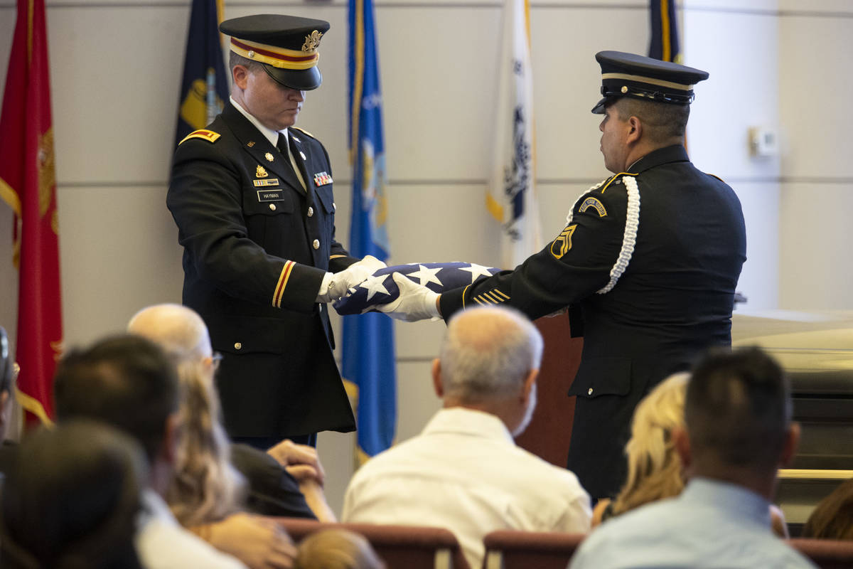 U.S. Army Lt. Kris Hayman, left, and Staff Sgt. Juan Marquez fold the American flag during a fu ...
