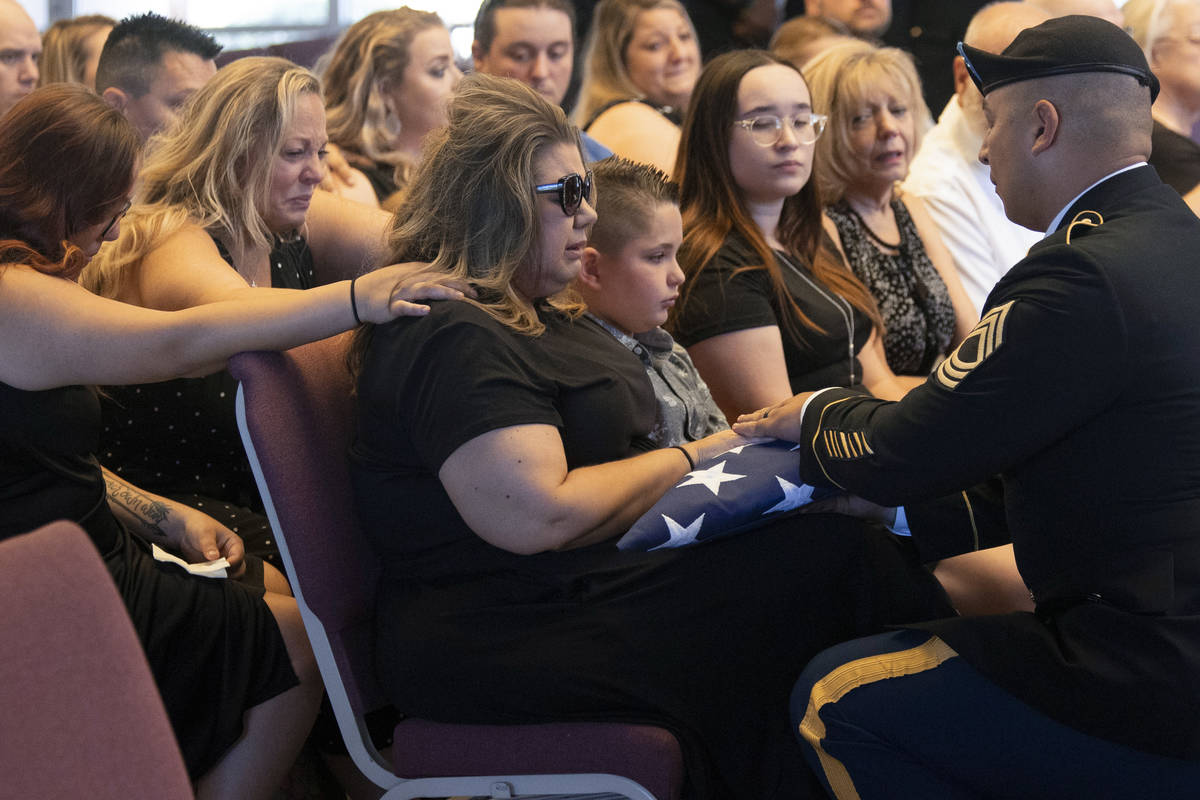 U.S. Army Master Sgt. Rafael Aguilera, right, presents the American flag to Christa Swanger, wi ...