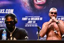 WBC heavyweight champion Tyson Fury, right, raises his fists as he walks near Deontay Wilder at ...