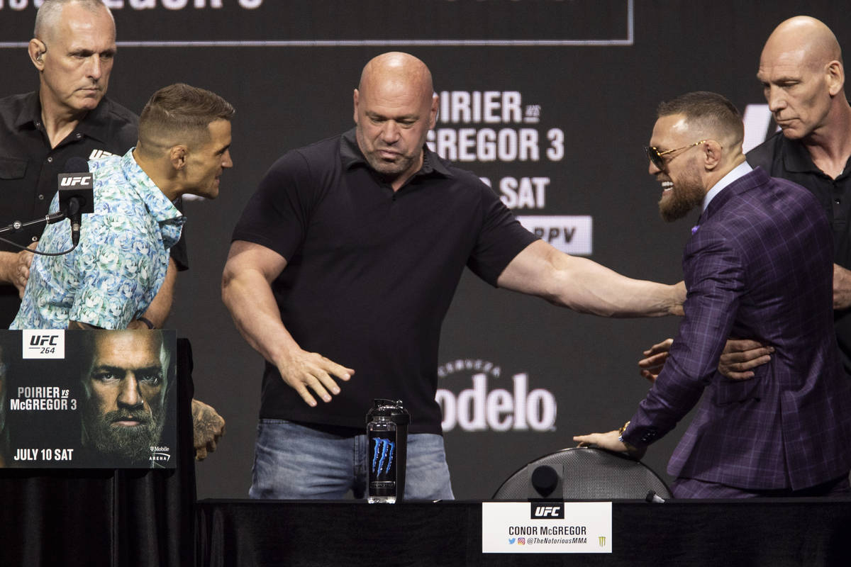 Dana White, center, stands between Dustin Poirier, left, and Conor McGregor during an UFC 264 p ...