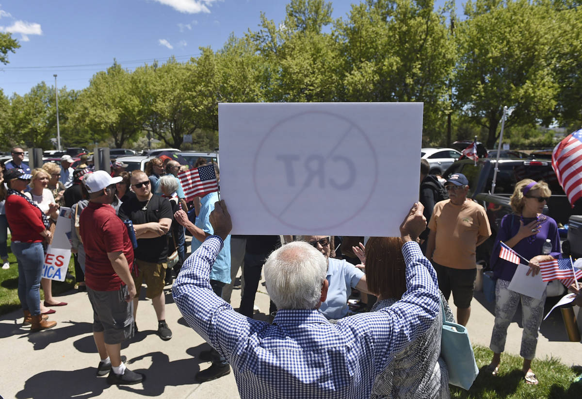 A man holds up a sign against Critical Race Theory during a protest outside a Washoe County Sch ...