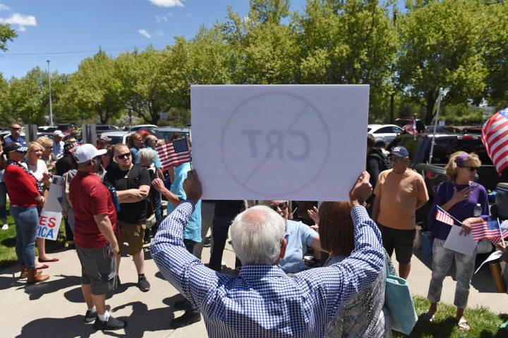 A man holds up a sign against Critical Race Theory during a protest outside a Washoe County Sch ...