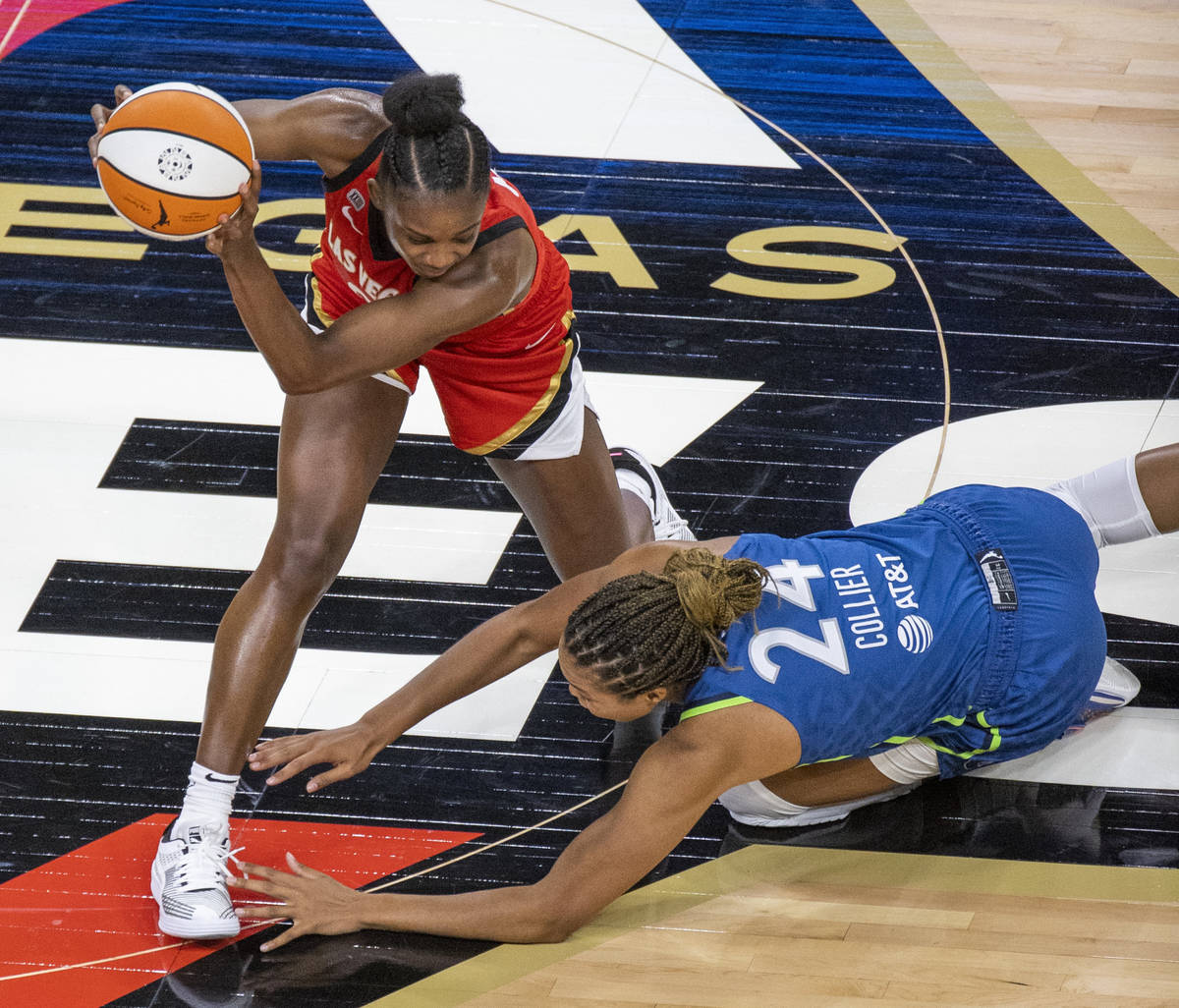 Las Vegas Aces guard Jackie Young (0) keeps a loose ball from Minnesota Lynx forward Napheesa C ...